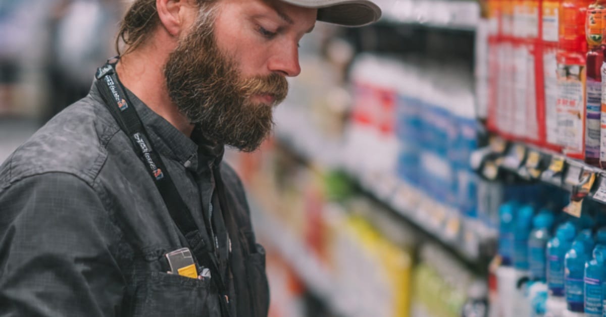 Merchandiser performing shelf audits and planogram checks using a mobile app