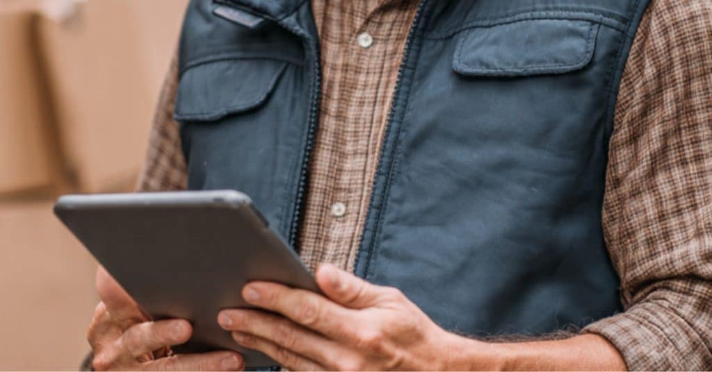 A delivery van sales representative managing distributor workflows on a mobile device