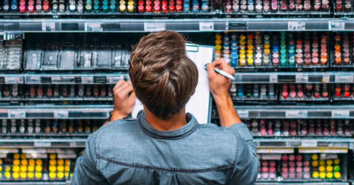 Merchandiser using a planogram to organize products during a shelf audit