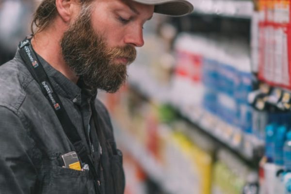 Merchandiser performing shelf audits and planogram checks using a mobile app