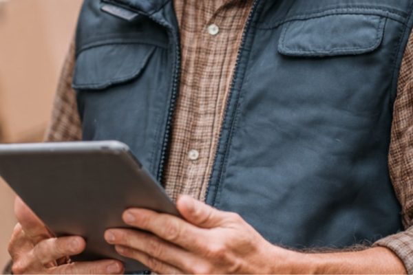 A delivery van sales representative managing distributor workflows on a mobile device