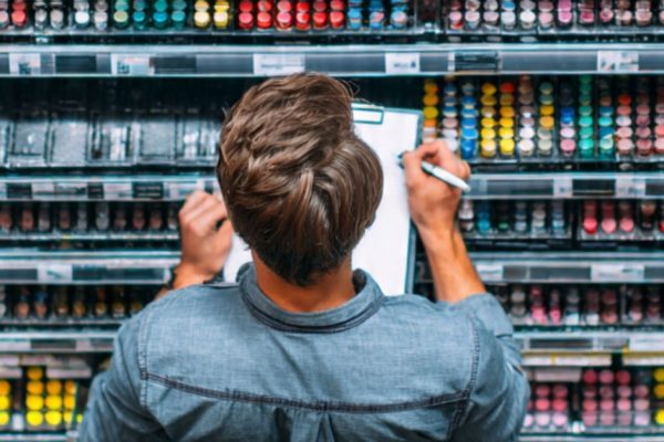 Merchandiser using a planogram to organize products during a shelf audit